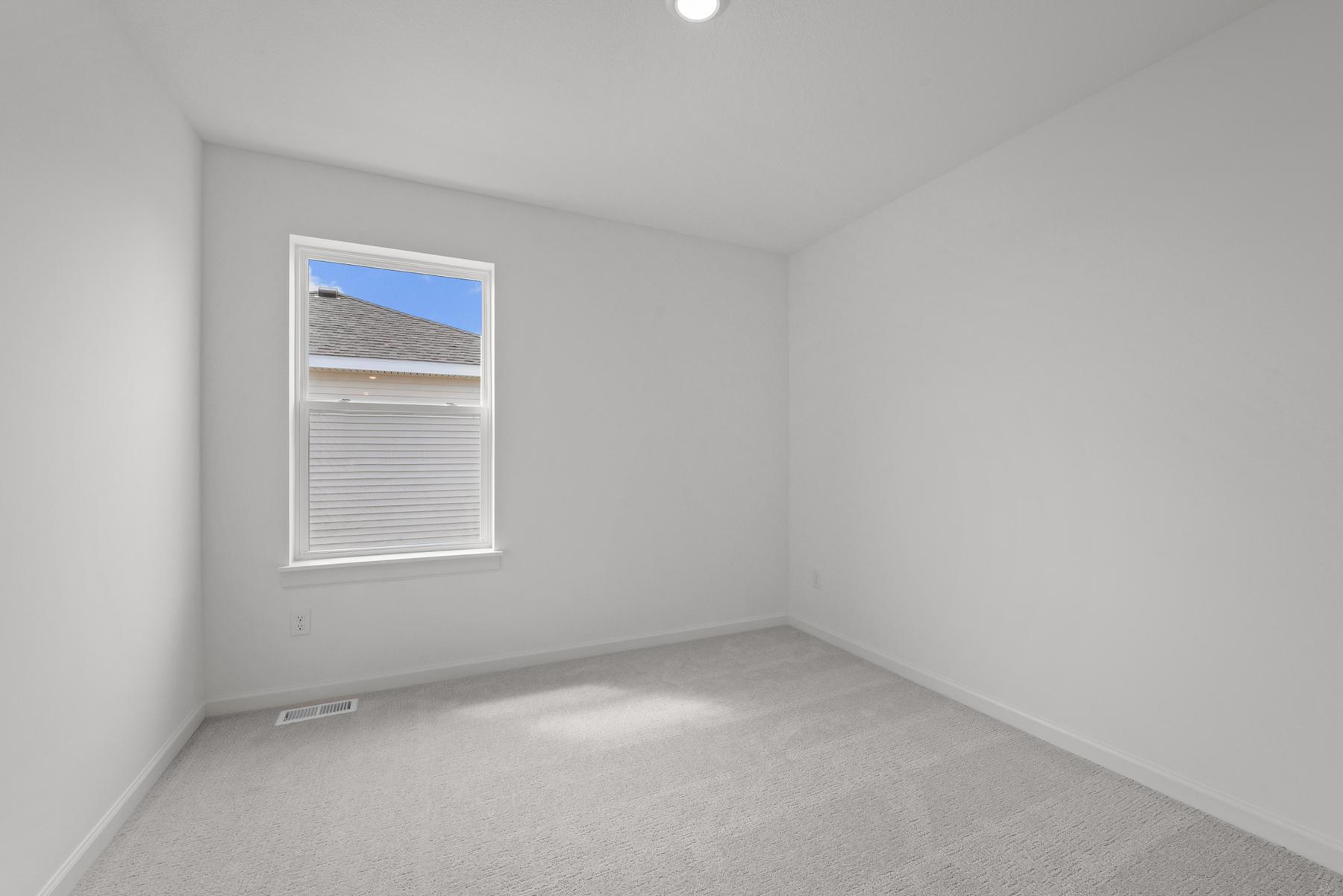 Comfortable secondary bedroom in the McBee plan ideal for guests or family use. Images are from a similar home, interior selections may differ