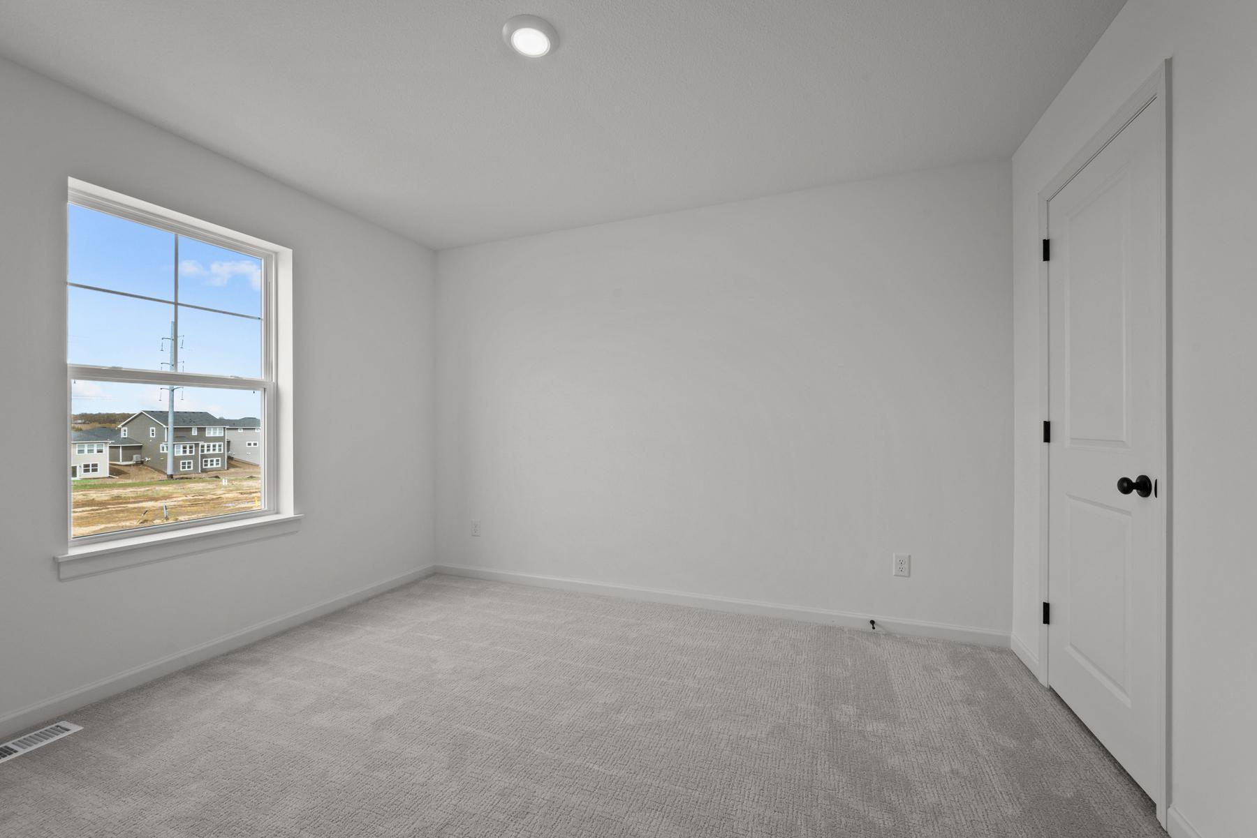 Comfortable secondary bedroom in the McBee plan ideal for guests or family use. Images are from a similar home, interior selections may differ