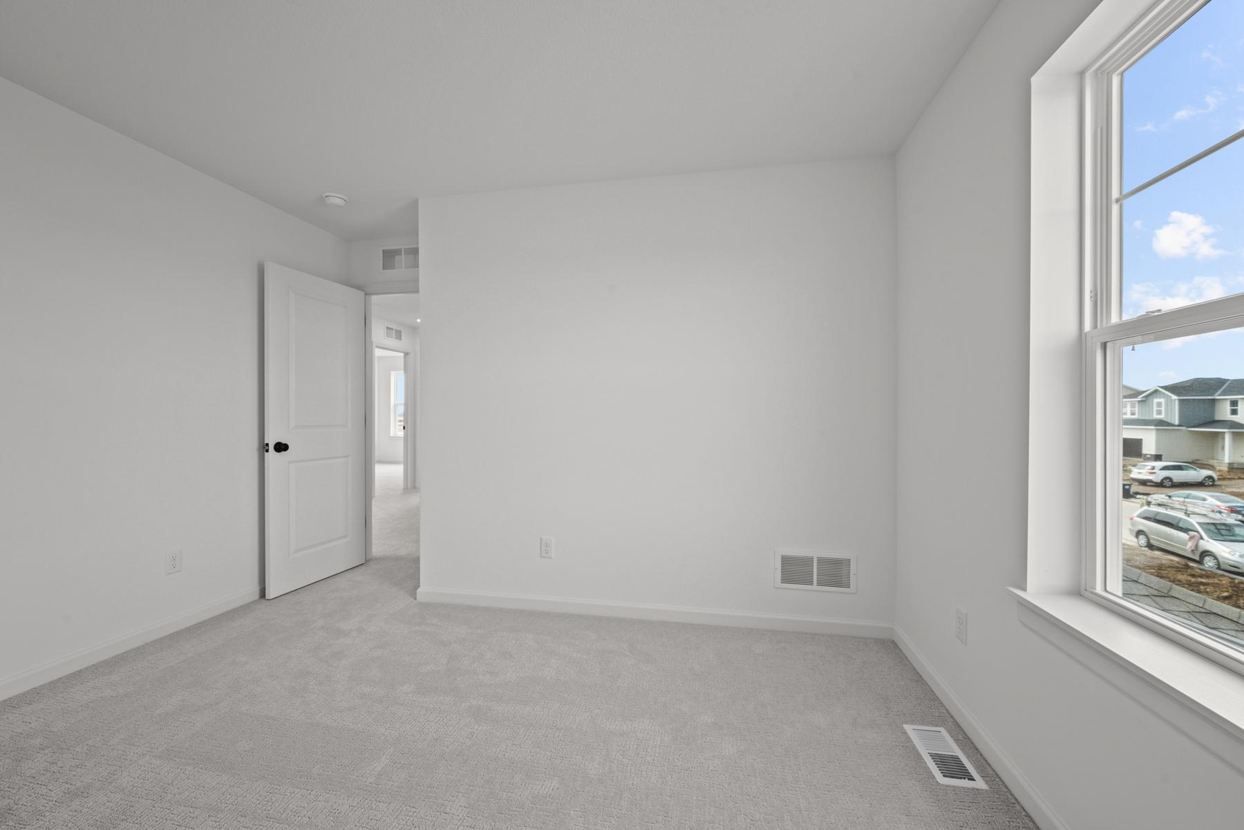 Comfortable secondary bedroom in the McBee plan ideal for guests or family use. Images are from a similar home, interior selections may differ
