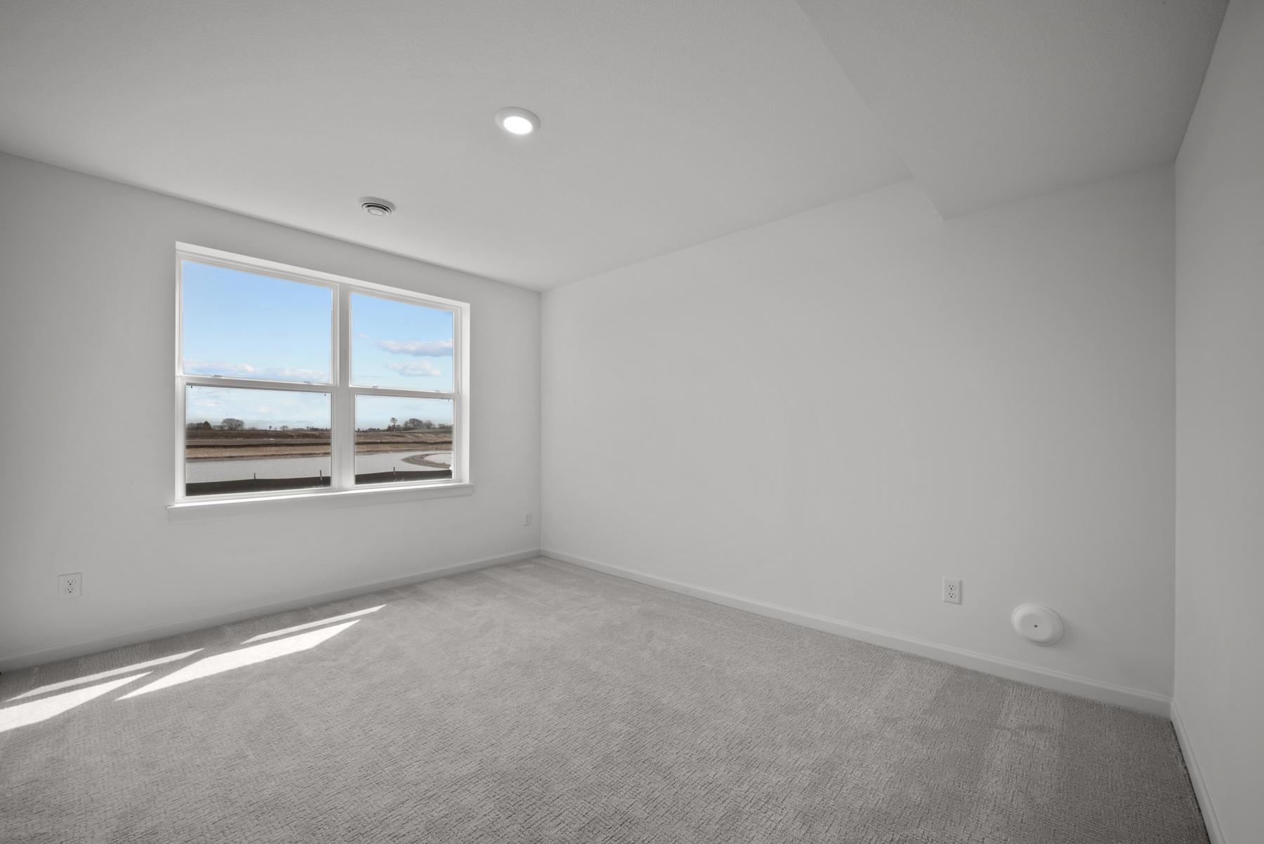 Comfortable secondary bedroom in the McBee plan ideal for guests or family use. Images are from a similar home, interior selections may differ