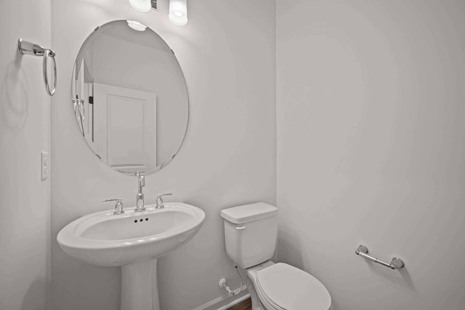 Main-level powder room in the McBee plan positioned for everyday convenience. Images are from a similar home, interior selections may differ