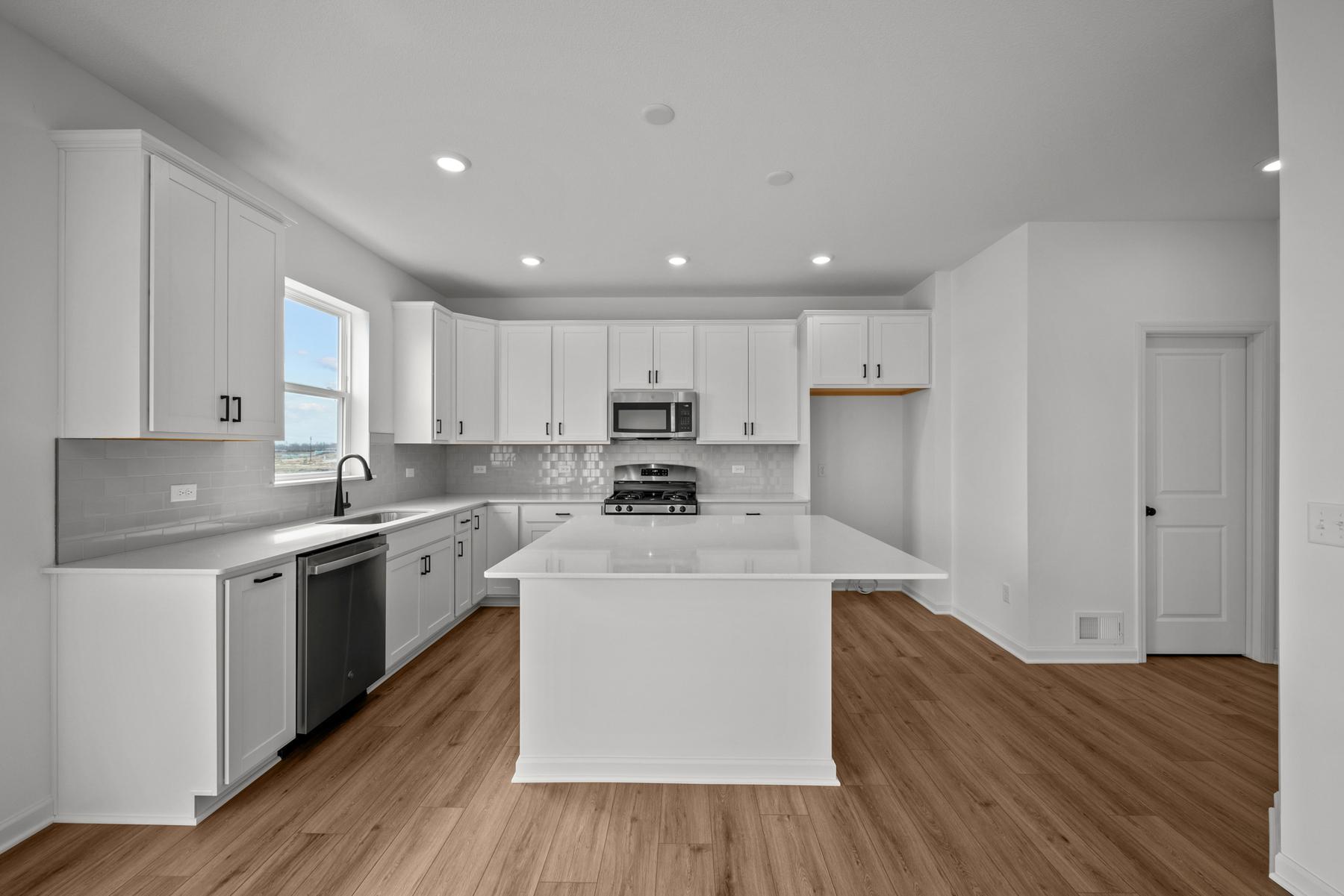 Central kitchen in the McBee plan designed for daily meals and casual gatherings. Images are from a similar home, interior selections may differ