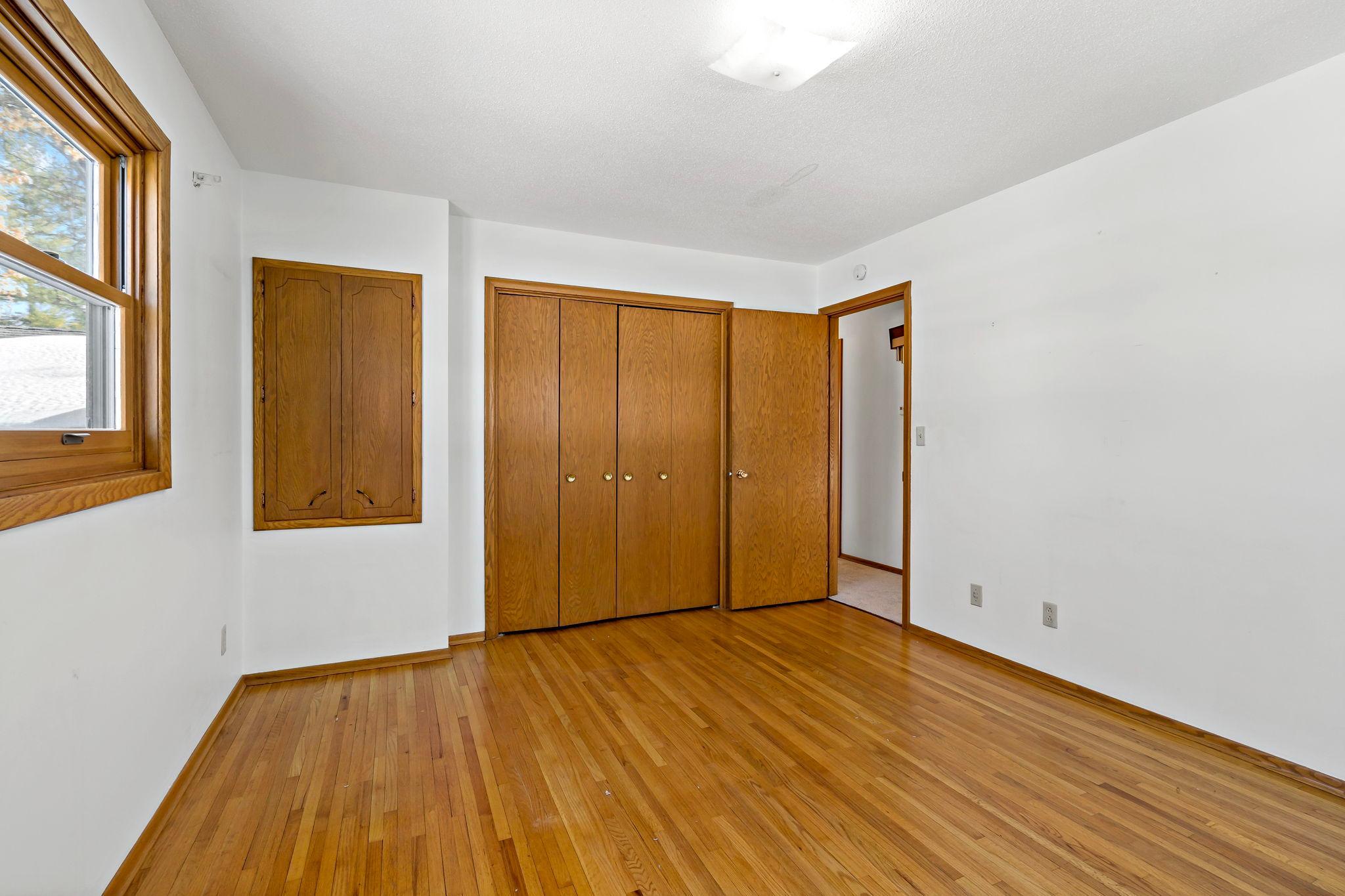 Second bedroom on upper level with original hardwood flooring.