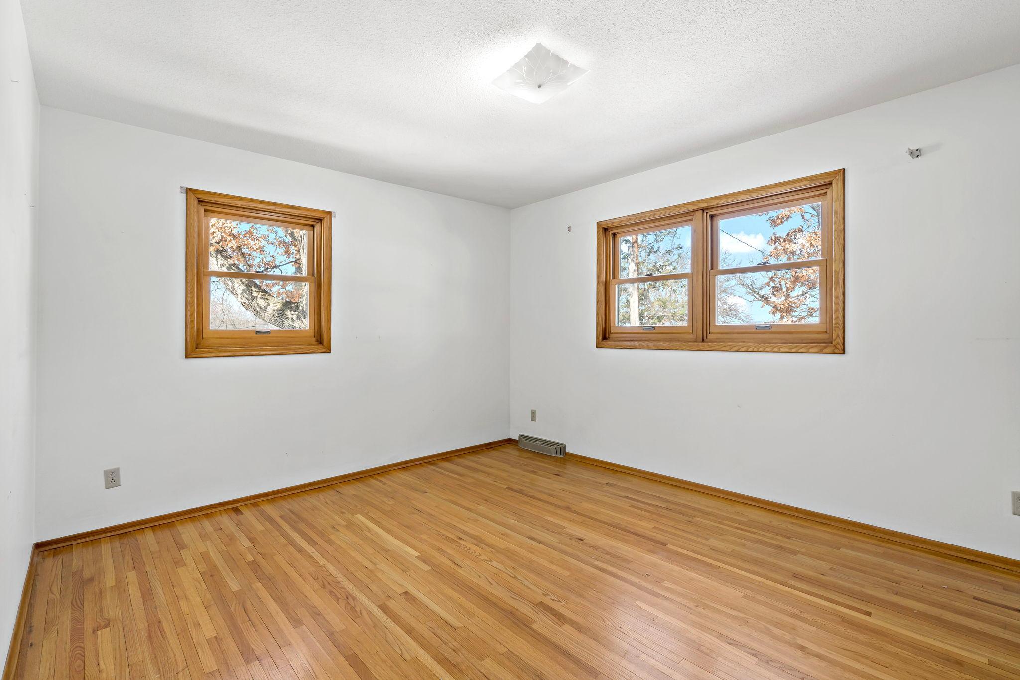 Second bedroom on upper level with original hardwood flooring.