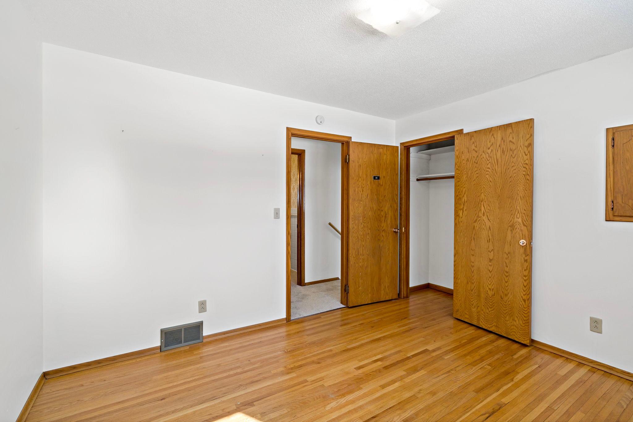 First bedroom on upper level with original hardwood floor.