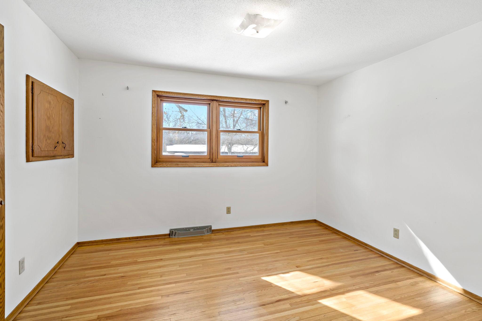 First bedroom on upper level with original hardwood floor.