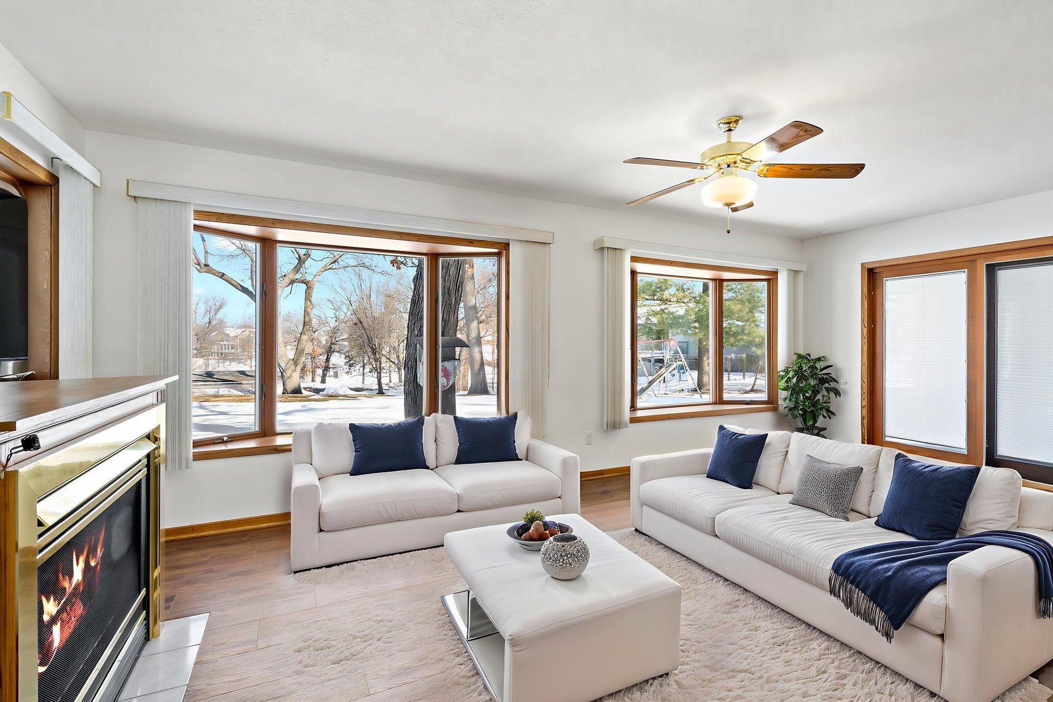 Sunroom with double bay windows facing Lower Prior Lake. Photo is virtually staged.