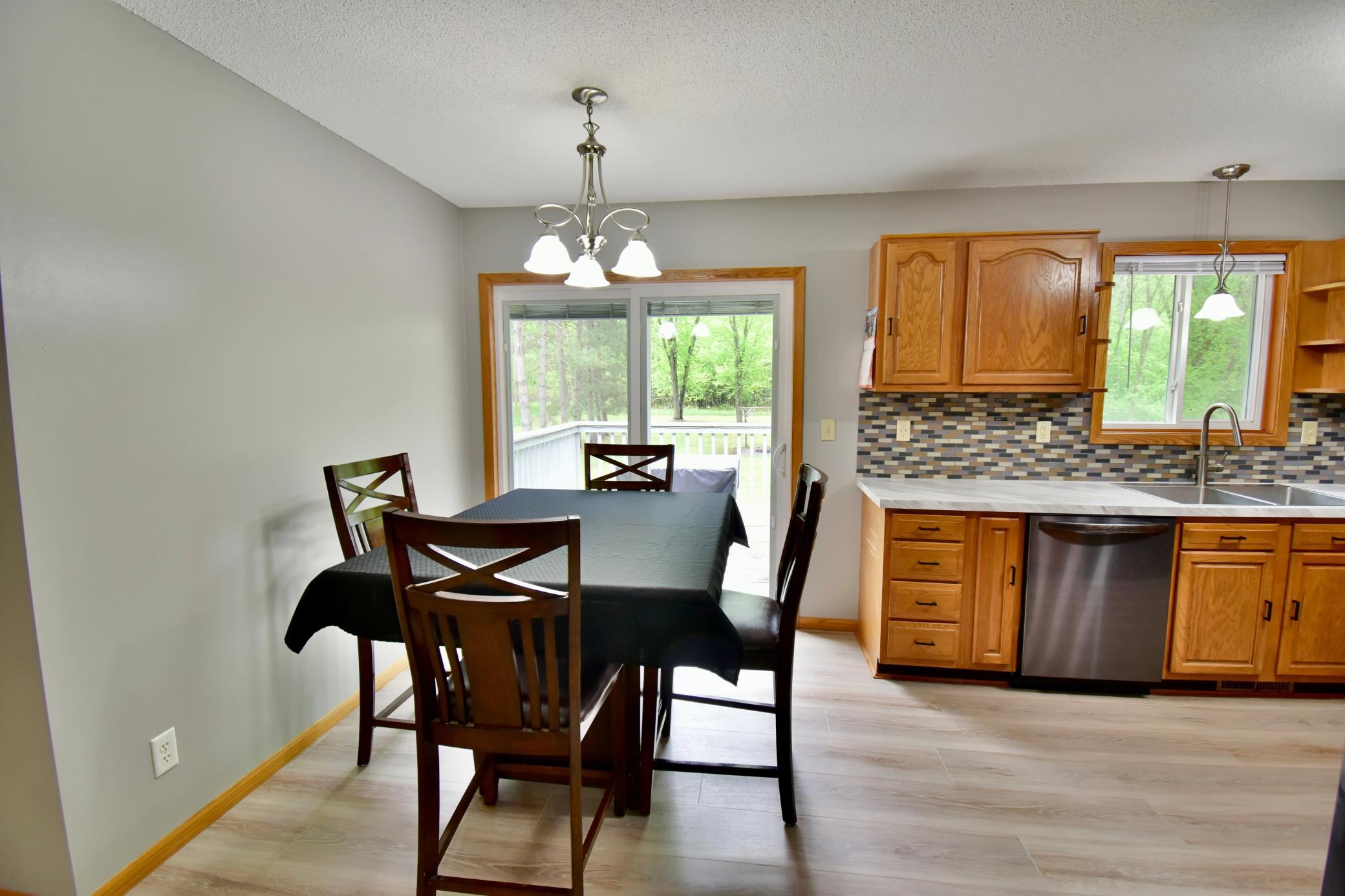 The dining area has that open concept feel with the kitchen on one side and the living room on the other side. You can access the deck right off the dining area. The Pella patio door was new in 2024.