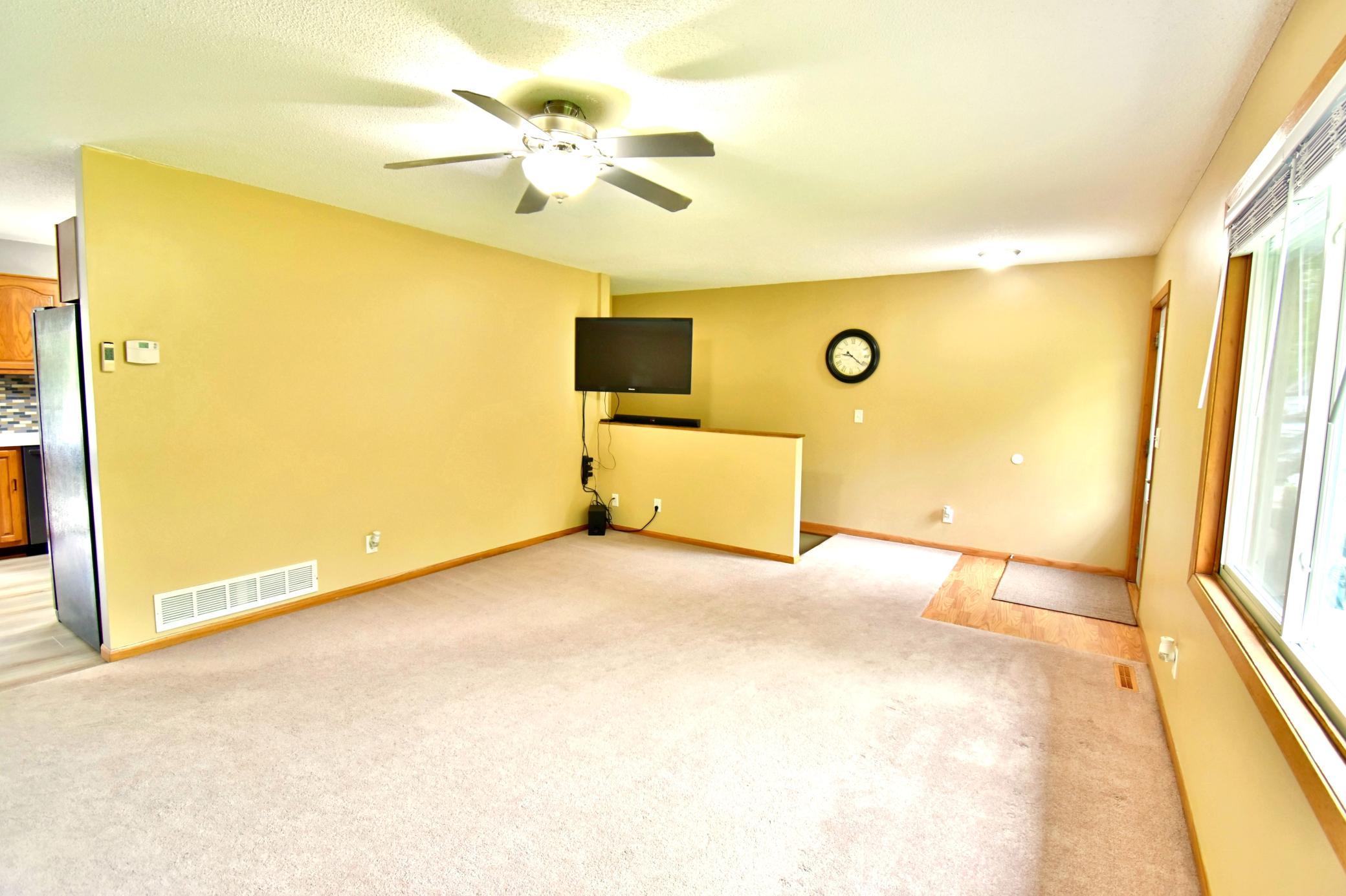 Large living room with a big window giving you lots of natural light and a good view of the front yard. The steps to the lower level are at the other end of this room.