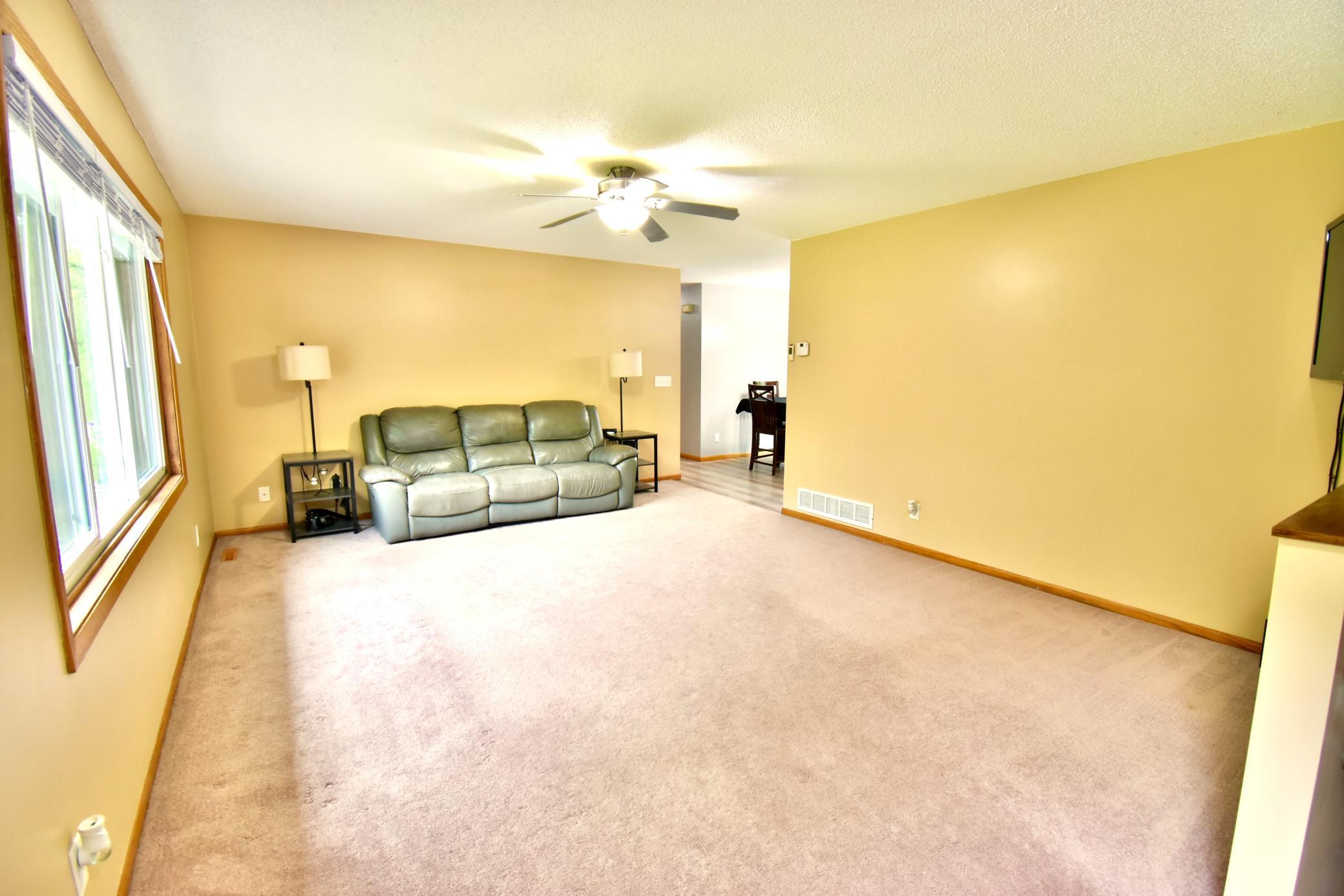 A view from the front door and stairs that lead to the lower level at the end of the living room.