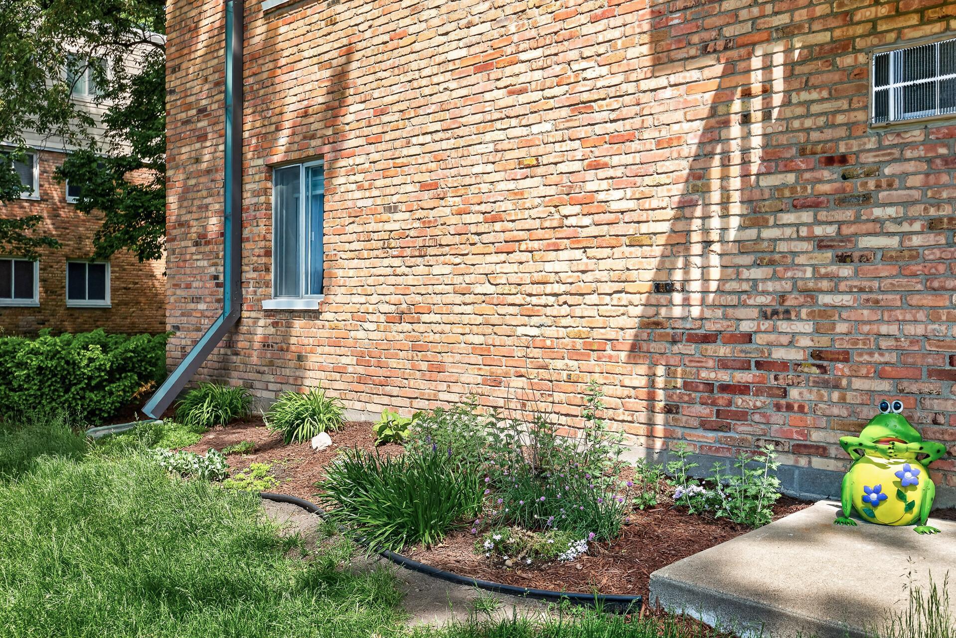 Just outside the walk-out patio, flowers are beginning to bloom, adding a warm and welcoming touch to this outdoor space.