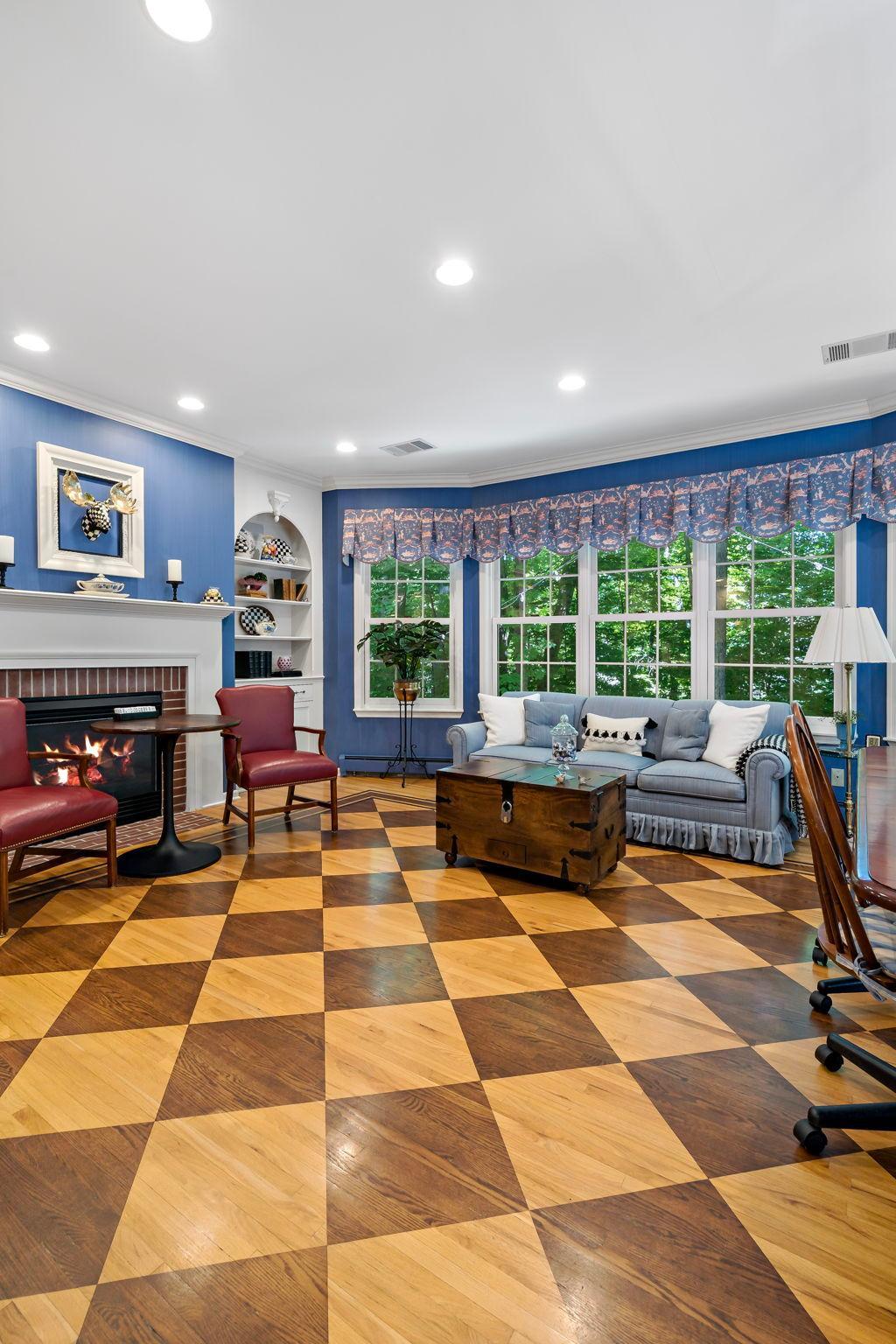 Step over into the family room with checked wood floors and cozy gas fireplace