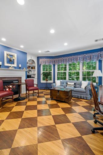 Step over into the family room with checked wood floors and cozy gas fireplace