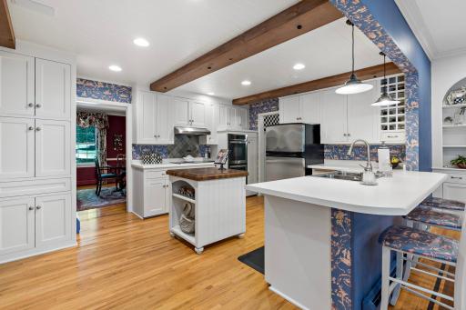 Bright and beautifully designed kitchen featuring ample cabinetry, stainless steel appliances, double ovens, and abundant prep space.