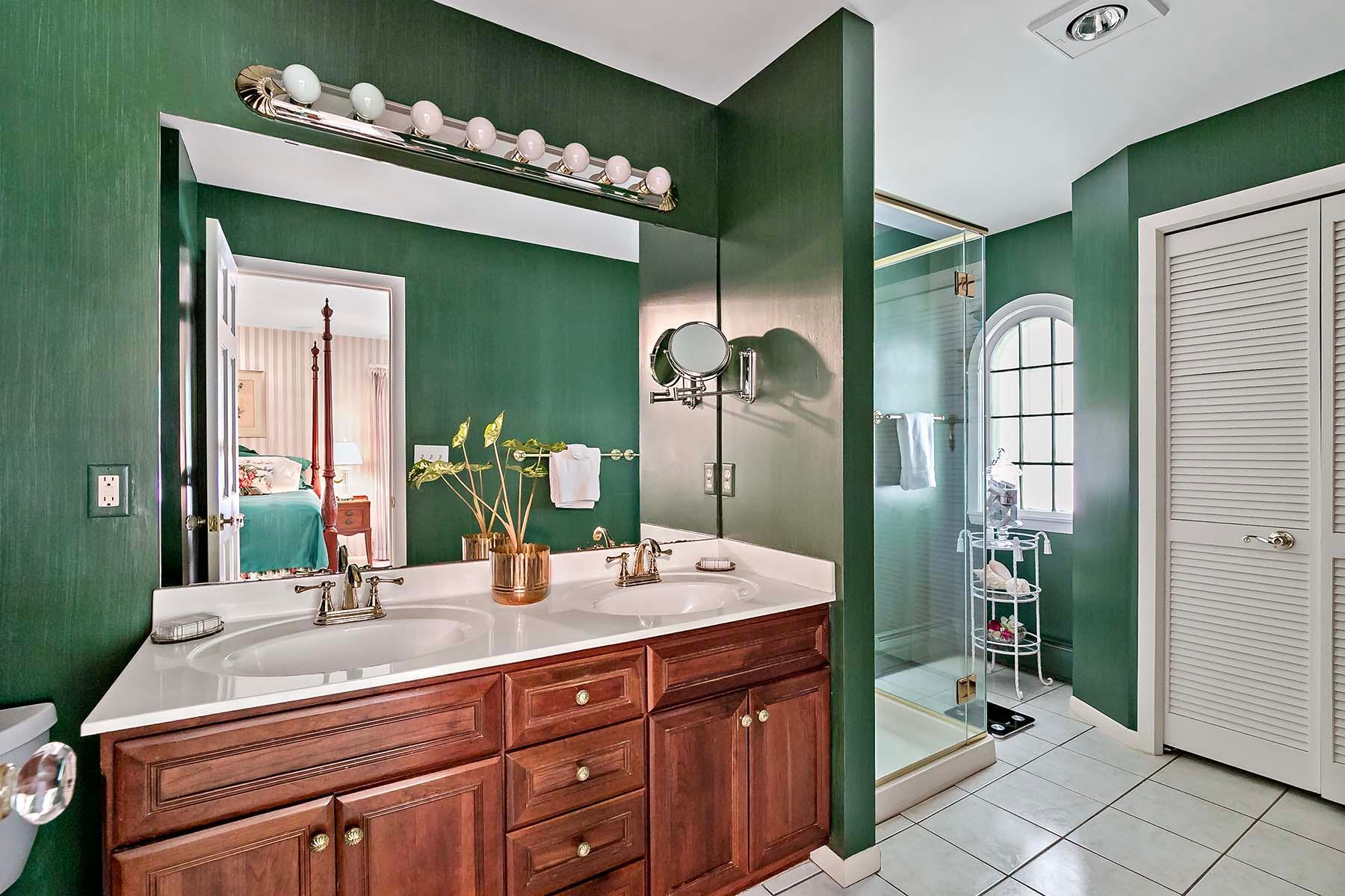 Primary bathroom features double sinks, tile flooring, and a walk-in shower