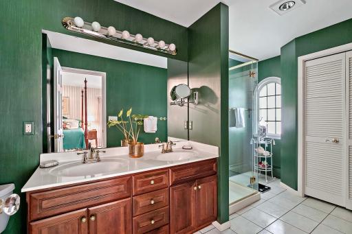 Primary bathroom features double sinks, tile flooring, and a walk-in shower