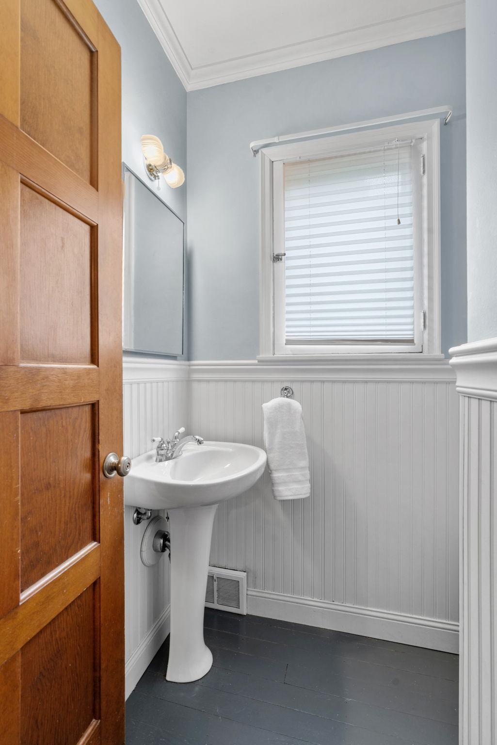 Main floor features a 1/2 bath which seller updated with Wainscotting