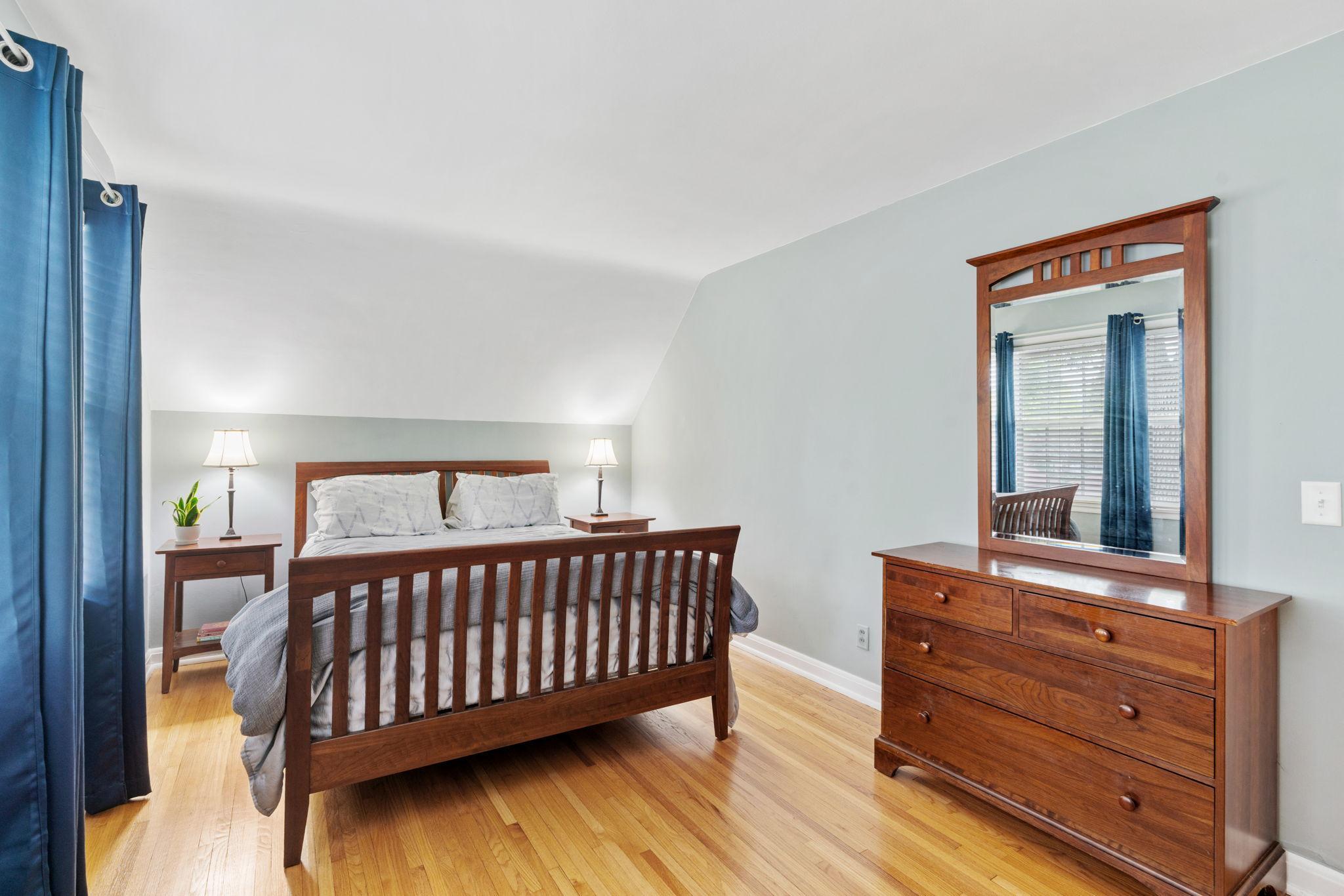 Primary features hardwood floors and space for dresser