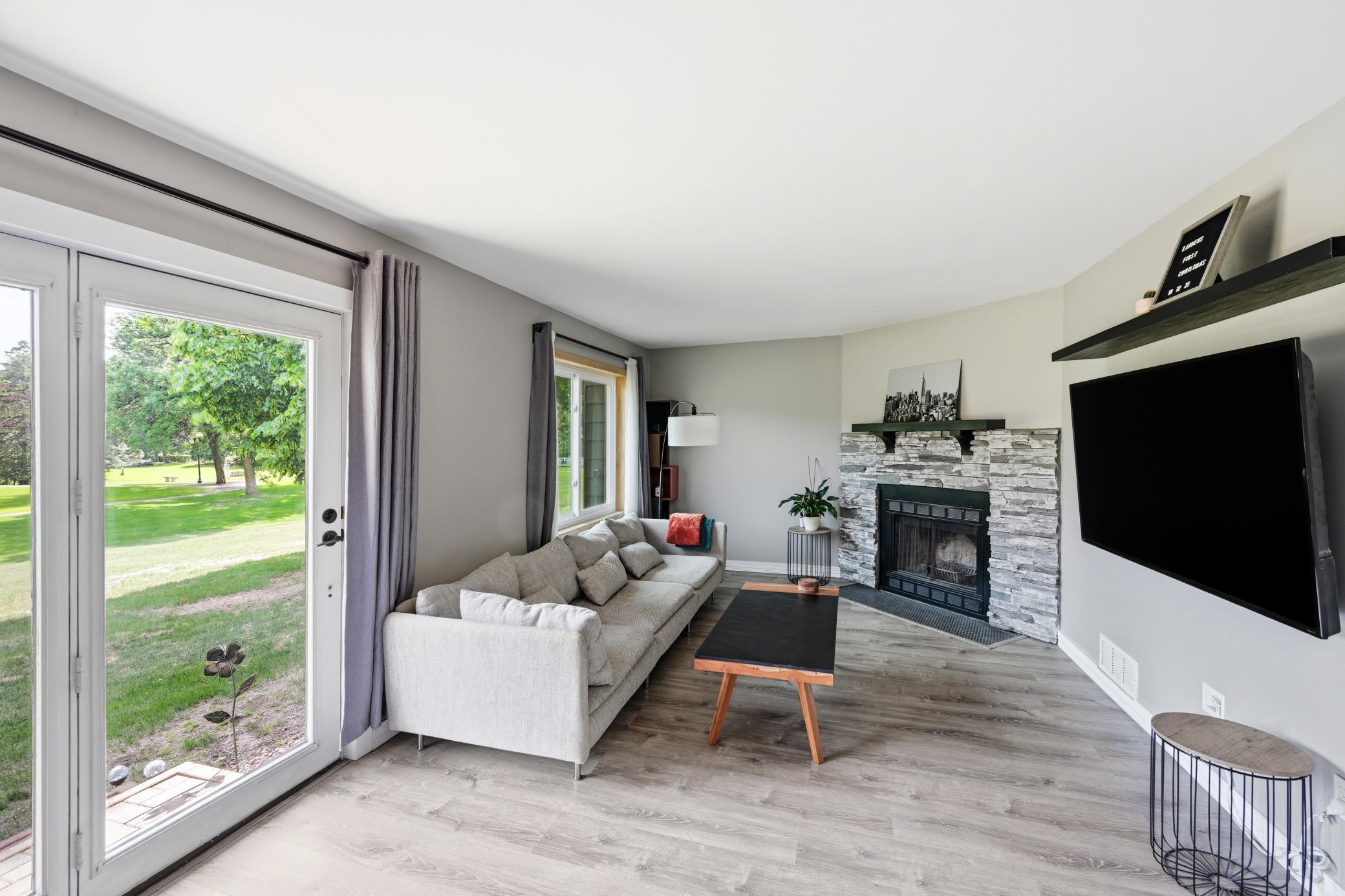 Large main level living room with wood burning fireplace.