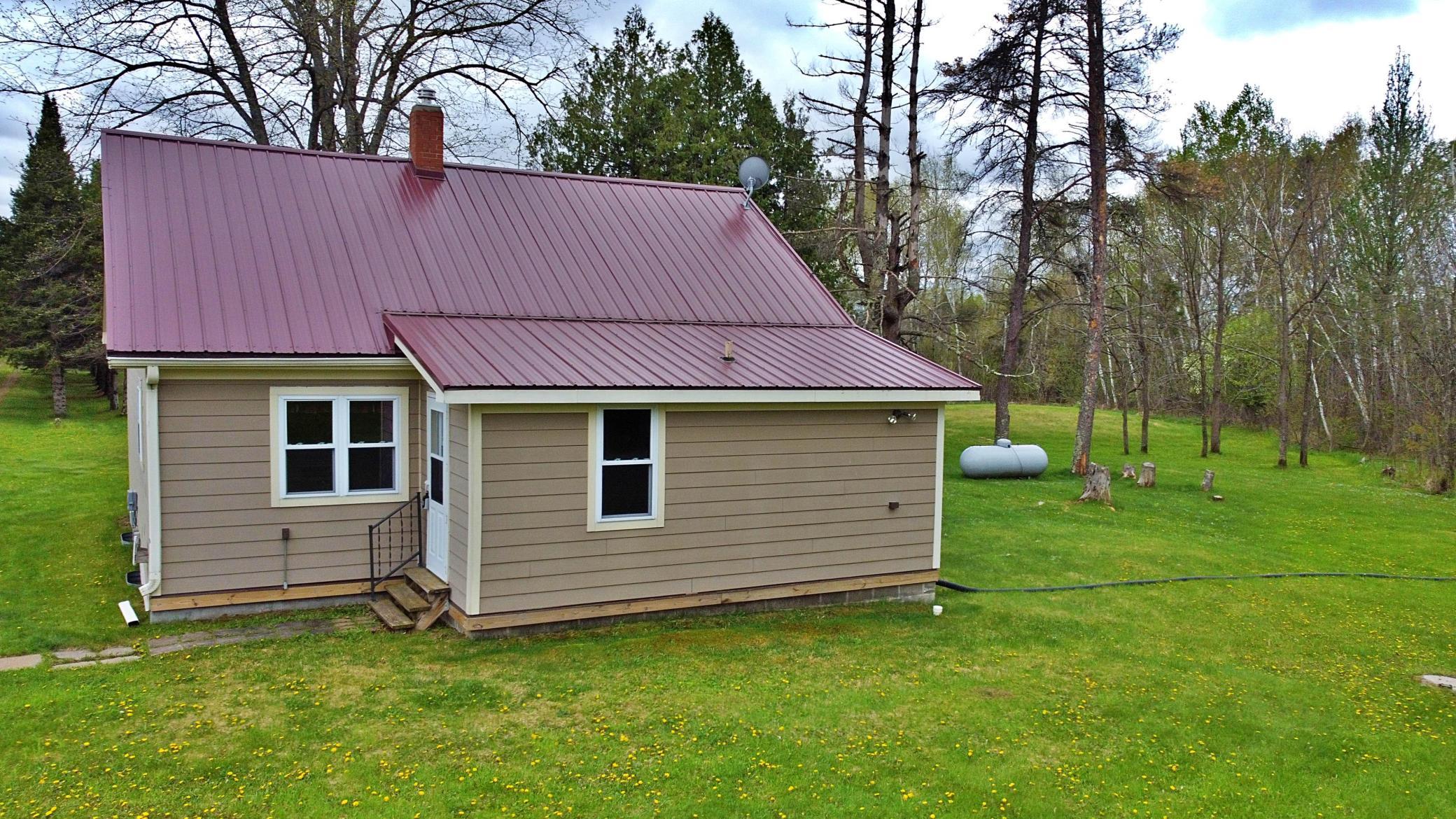 Home photo with metal roof and propane tank.jpg