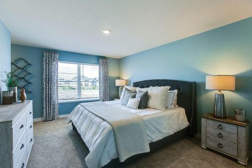Unwind after a long day in your upper level primary suite with attached bath. Color and options will vary.