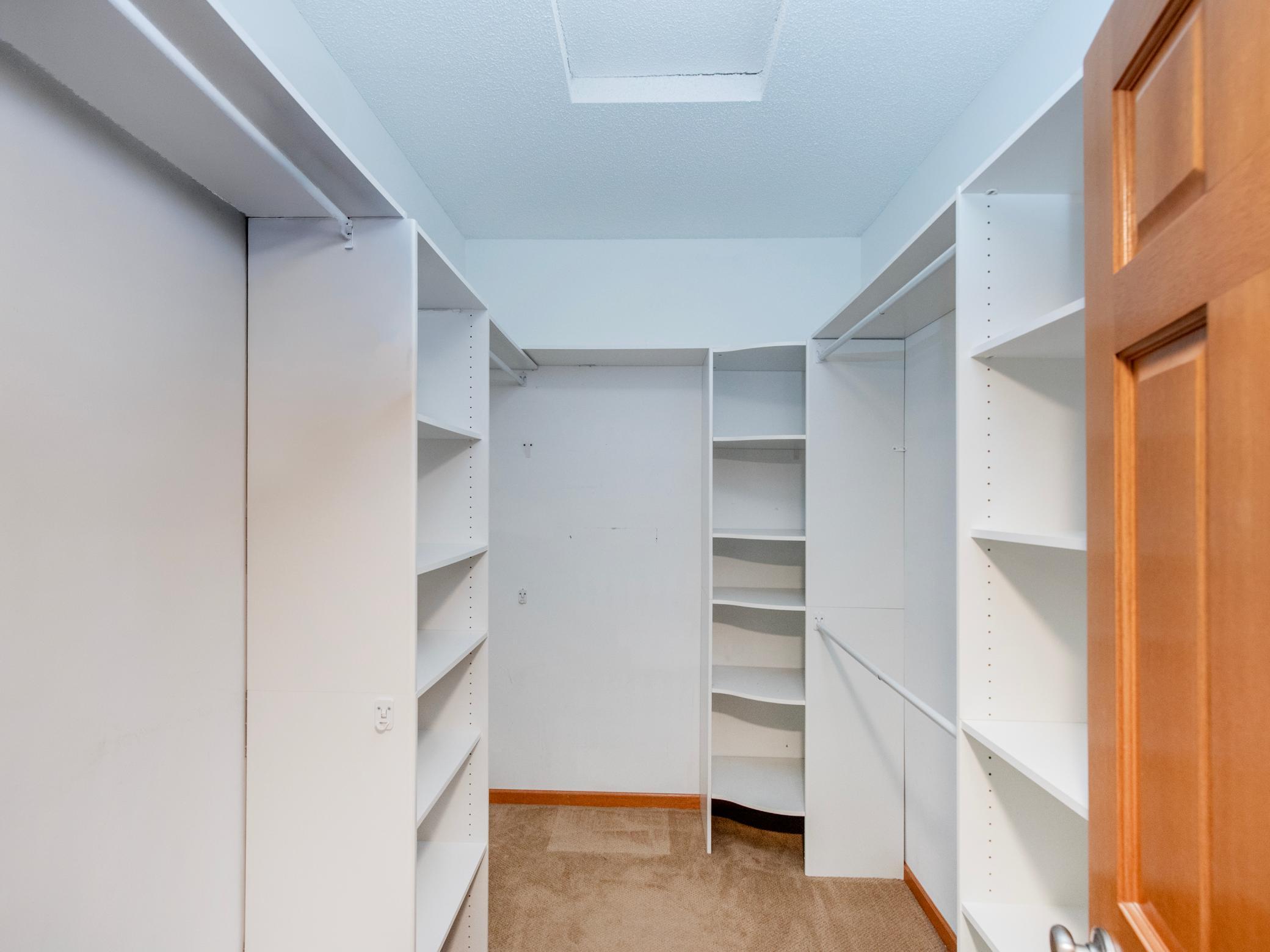 Spacious walk-in closet with built-in shelving in the owner's suite.