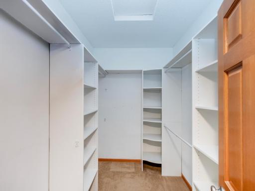 Spacious walk-in closet with built-in shelving in the owner's suite.