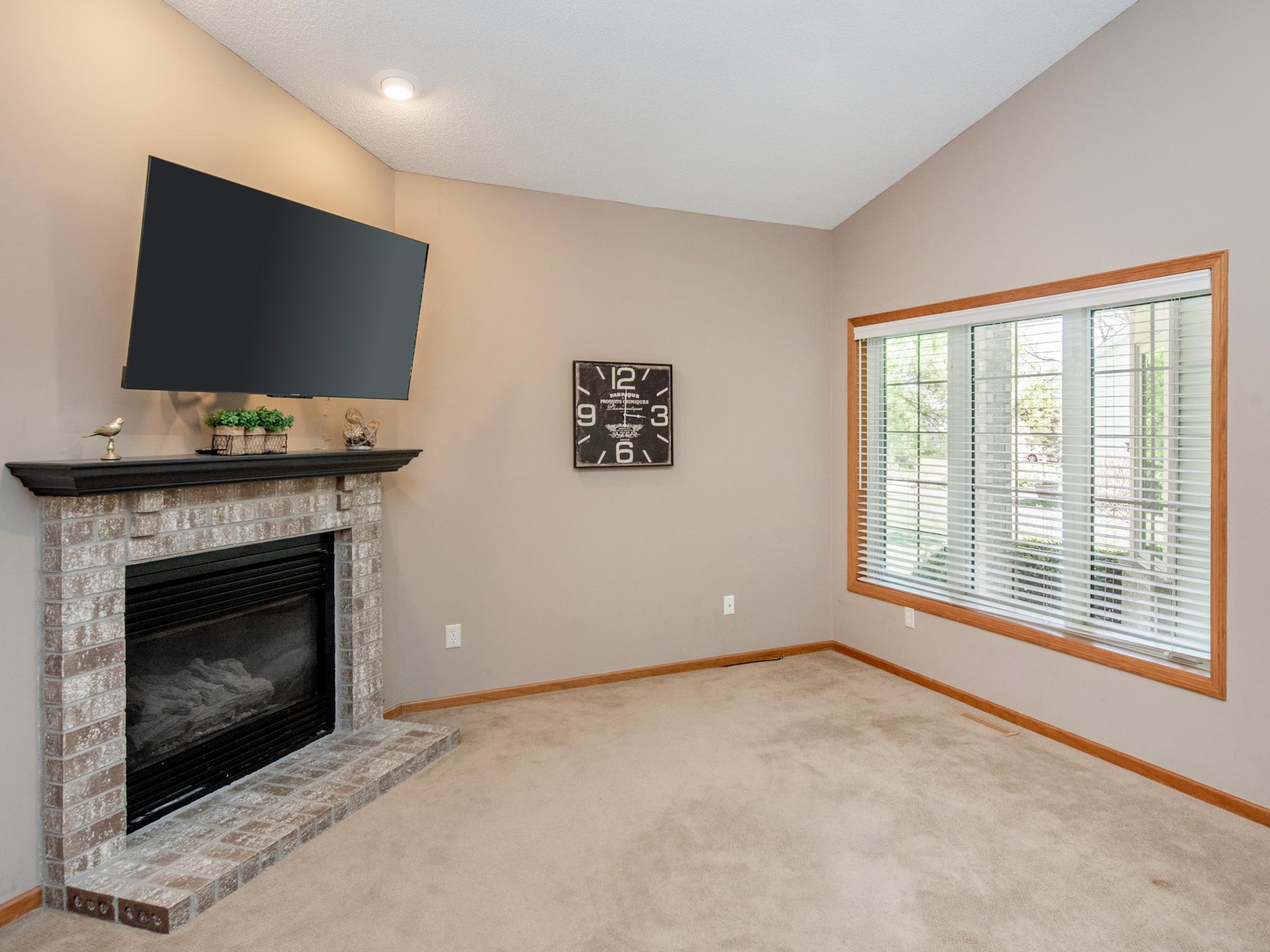 Inviting living area featuring vaulted ceilings and a gas fireplace.