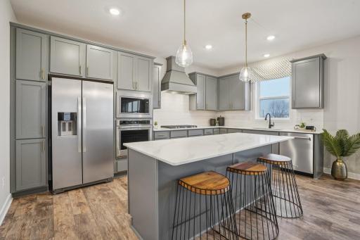 Elegant quartz countertops, stainless appliances, Gourmet kitchen, and a window looking into the backyard - the stuff kitchen dreams are made of! Model photo, options and colors may vary.