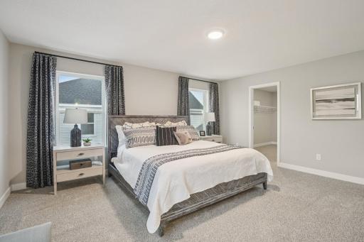 This primary bedroom is spacious and comfortable and features a jaw-dropping walk-in closet. Model photo, options and colors may vary.