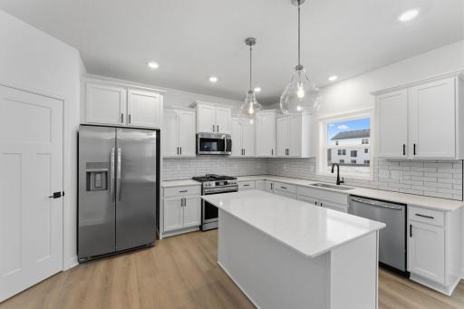 (Photo of a similar home, actual finishes may vary) The open-concept design allows for effortless transitions between cooking, eating and relaxing on the couch