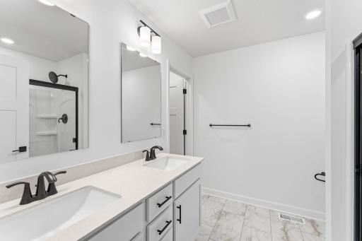 (Photo of a similar home, actual finishes may vary) Rectangular dual sinks at this spacious quartz-topped vanity promote streamlined morning routines