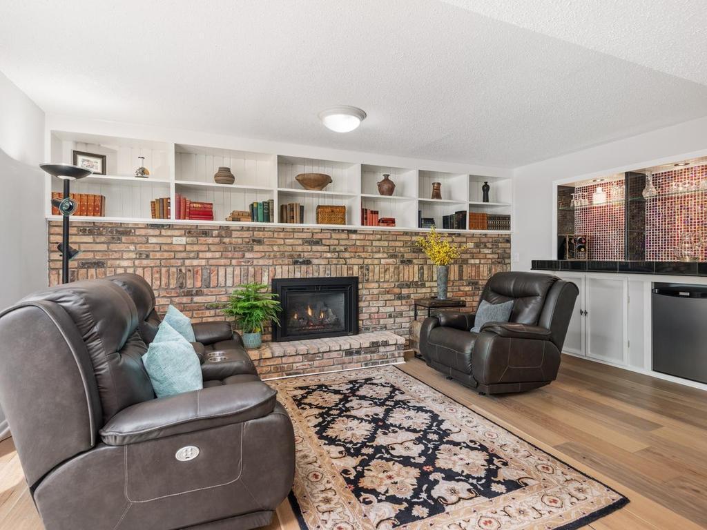 Lower level Family Room with gas fireplace wall and attractive bar area.