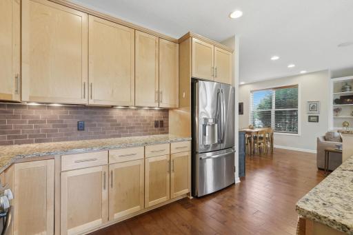 The tile backsplash and under cabinet lighting add a polished finishing touch and warm ambiance to the kitchen.
