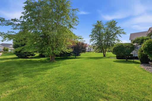 Lush, mature plantings frame the backyard with layers of greenery, creating a lovely backdrop for enjoying the deck and outdoor surroundings.