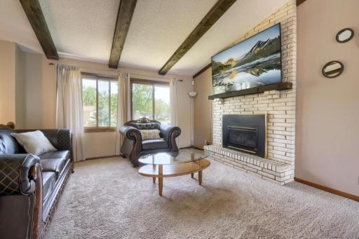 The living room offers high vaulted ceilings and a gas burning fireplace with an all-brick surround.