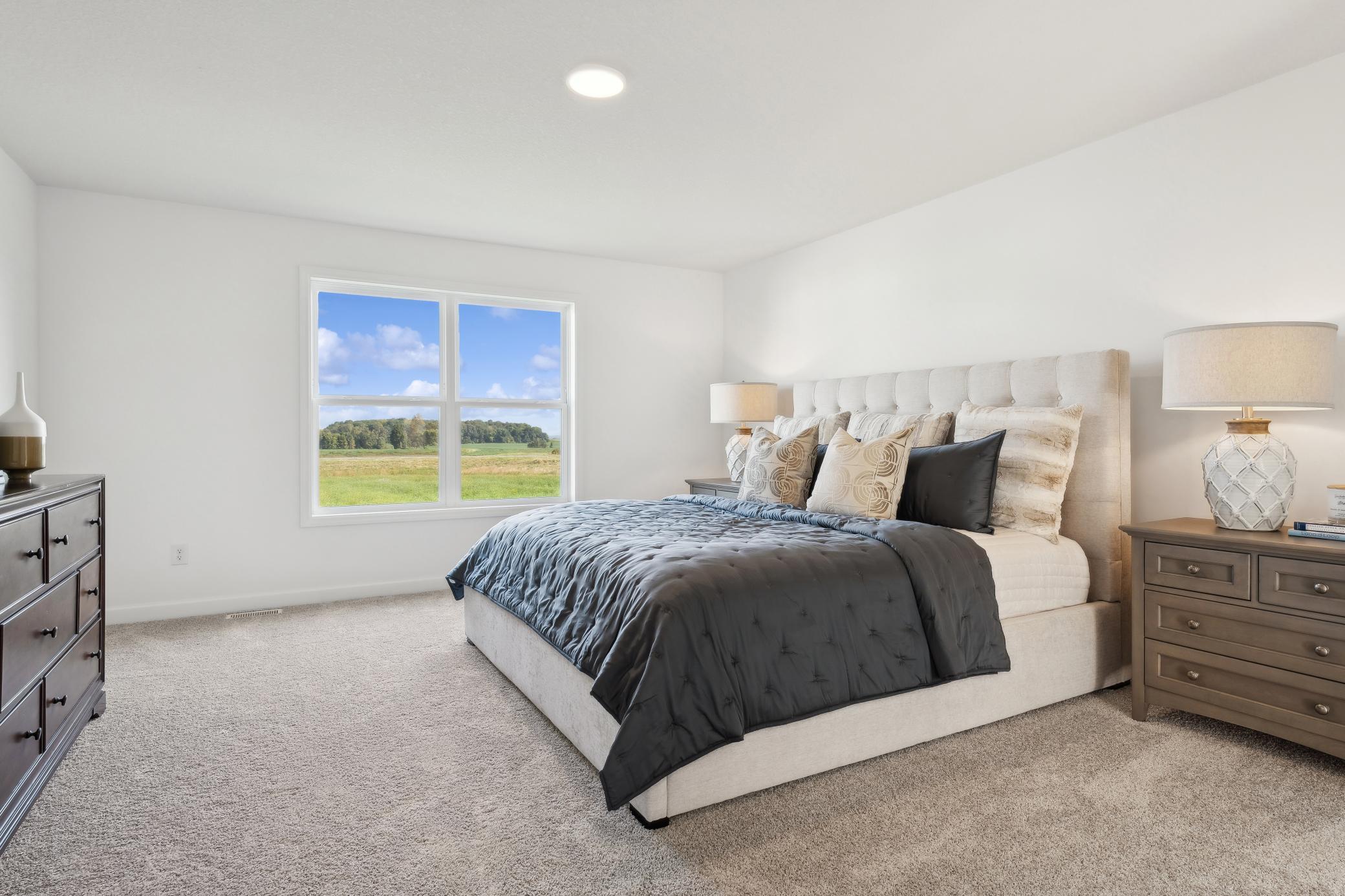 (Photo of a decorated model, actual homes finishes will vary) Be impressed with the large primary bedroom that offers its own private ensuite bath and walk-in closet.