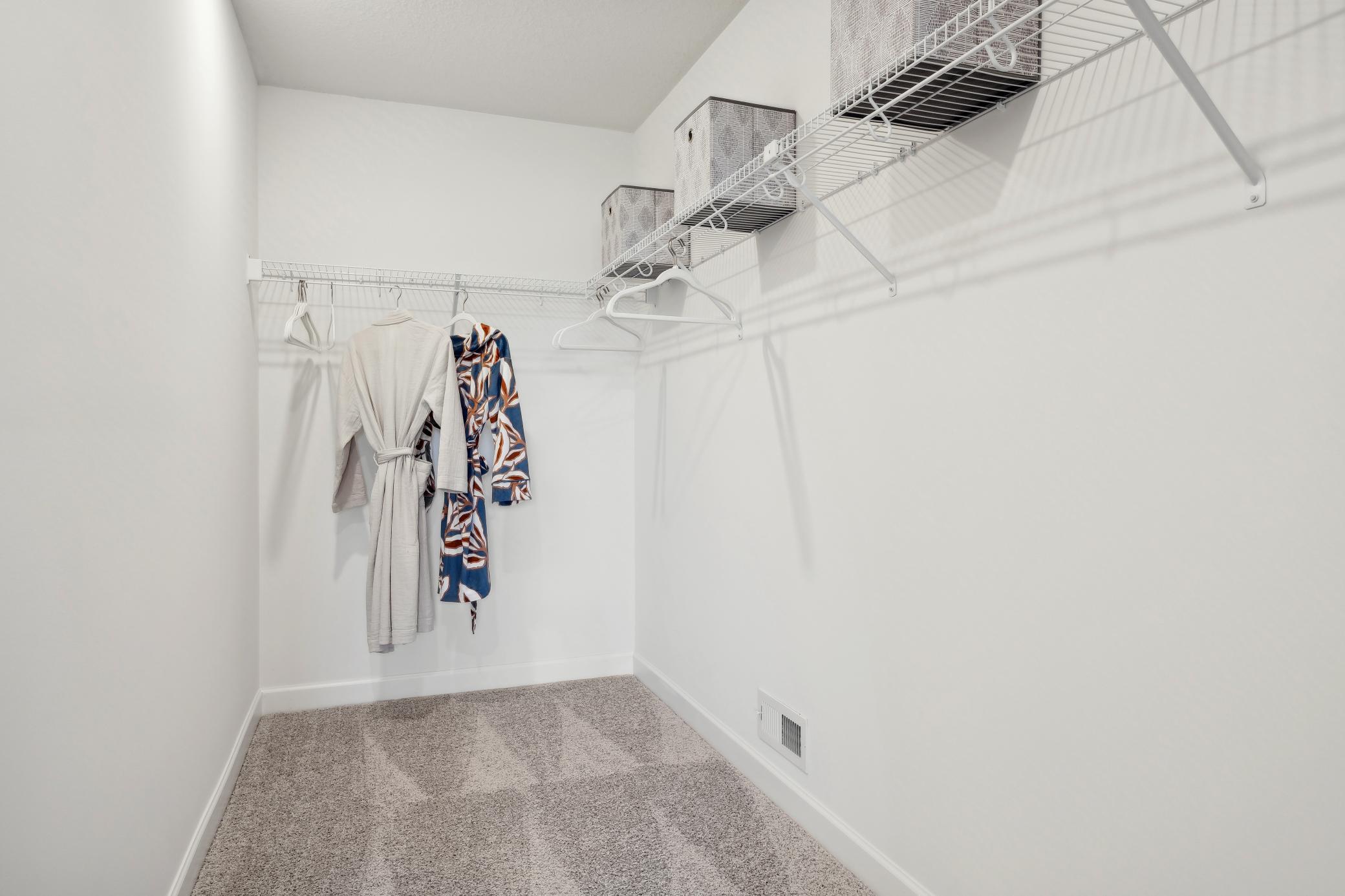 (Photo of a decorated model, actual homes finishes will vary) The primary bedroom walk-in closet.