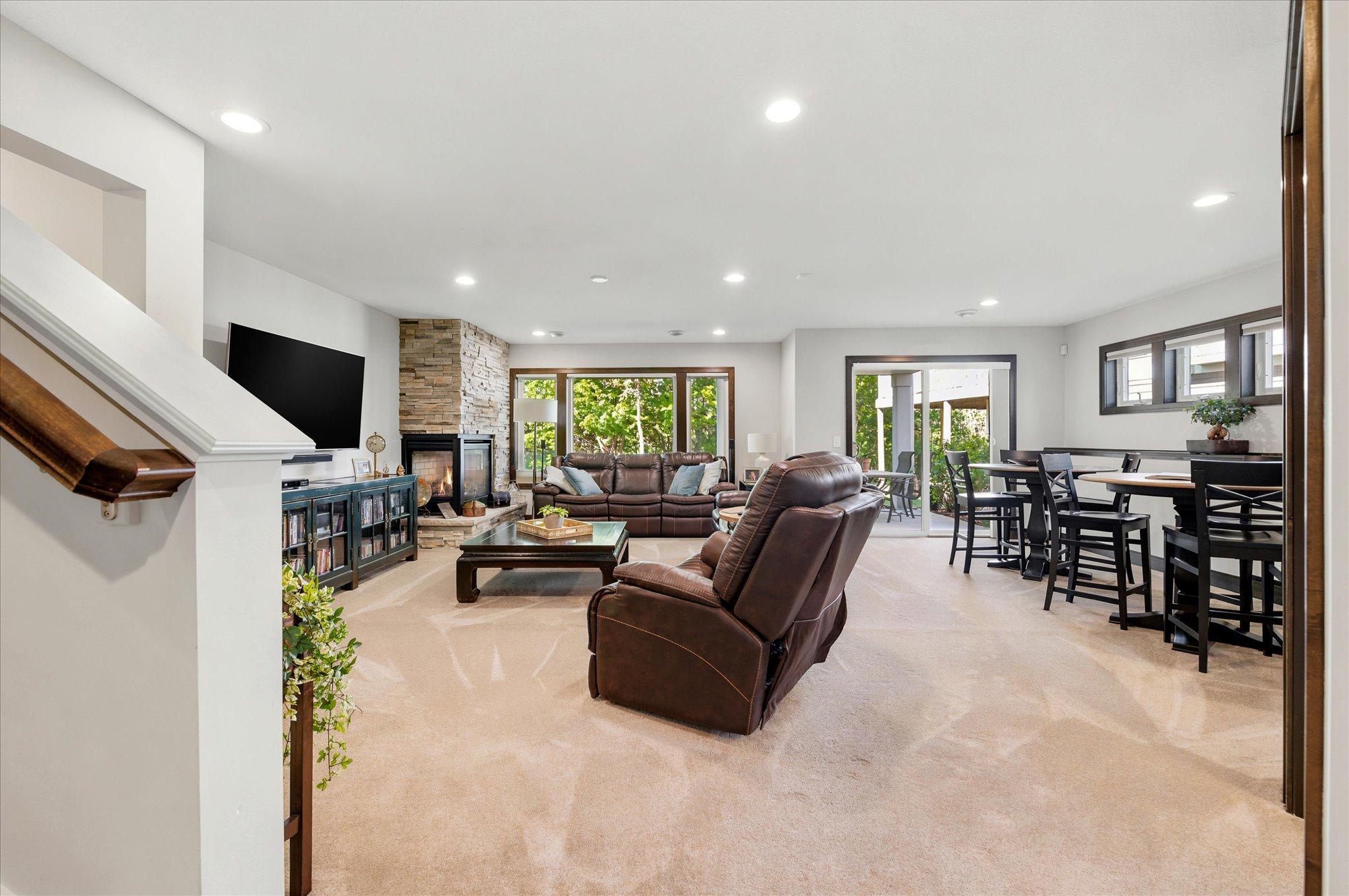 Spacious lower level family room steps out to a patio and private green space