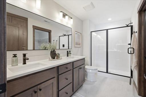 Primary ensuite bath with dual vanity and walk-in shower.
