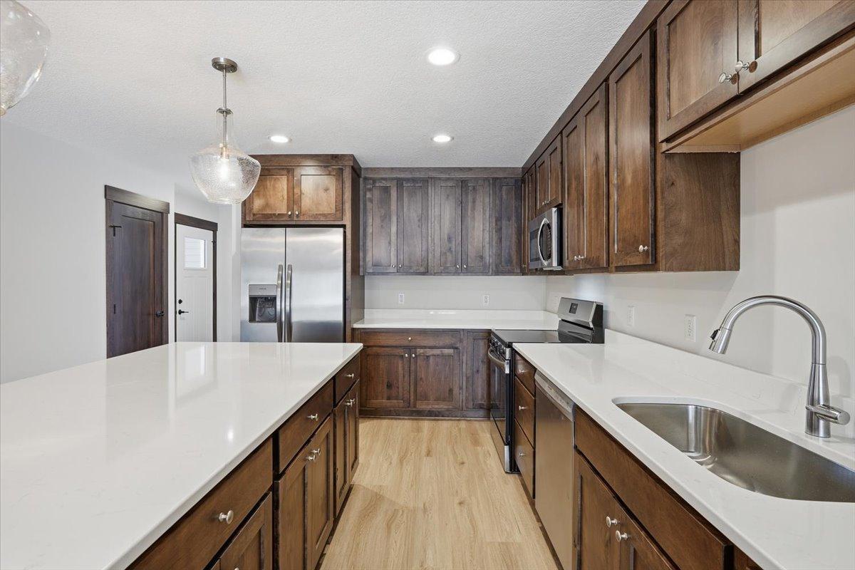 Gorgeous dark wood with white countertops and backsplash.