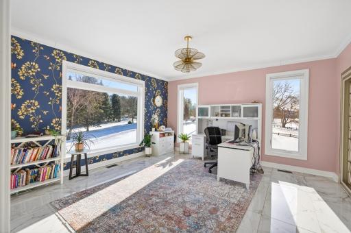 The main-level office features a cozy double-sided fireplace shared with the family room, showcased by a full-height marble surround.