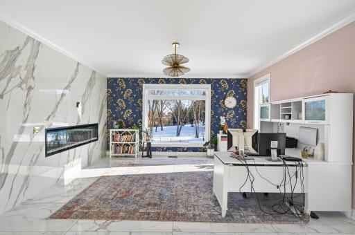 Marble flooring continues throughout the space, while a large window provides abundant natural light and serene backyard views.