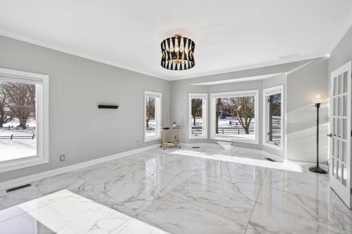 The spacious living room is equally impressive, featuring marble floors and an abundance of windows, including a front-facing bay window.