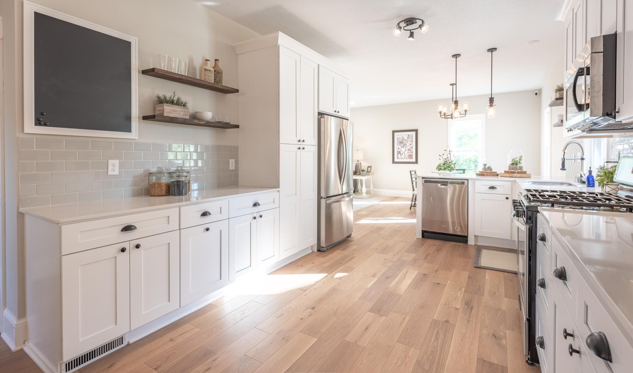 Pantry cabinet provides for plenty of storage. Accent shelves, quartz countertops, and tile backsplash completes the upgraded look of this spacious kitchen