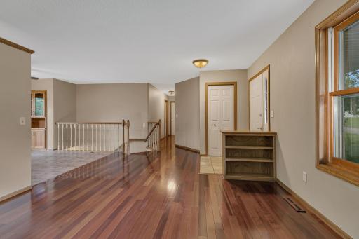 Cherry wood flooring continues down the hall and into the first guest room