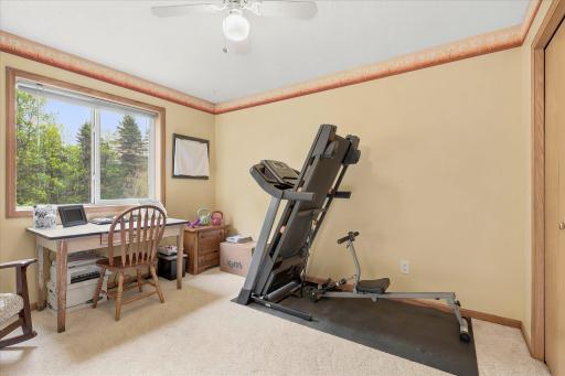 This is the 2nd bedroom on the upper level of the home currently being used as an office and workout area.