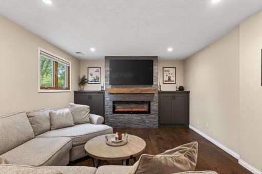 Cozy lower-level family room with fireplace and built-ins
