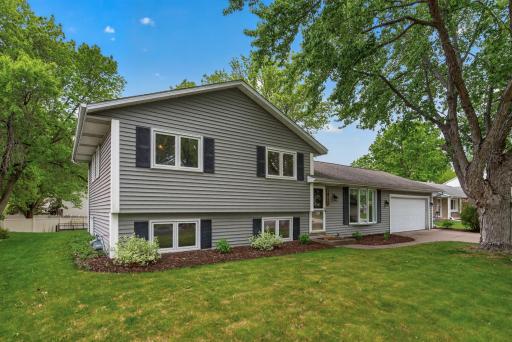 Front/side exterior showcasing mature trees and landscaping