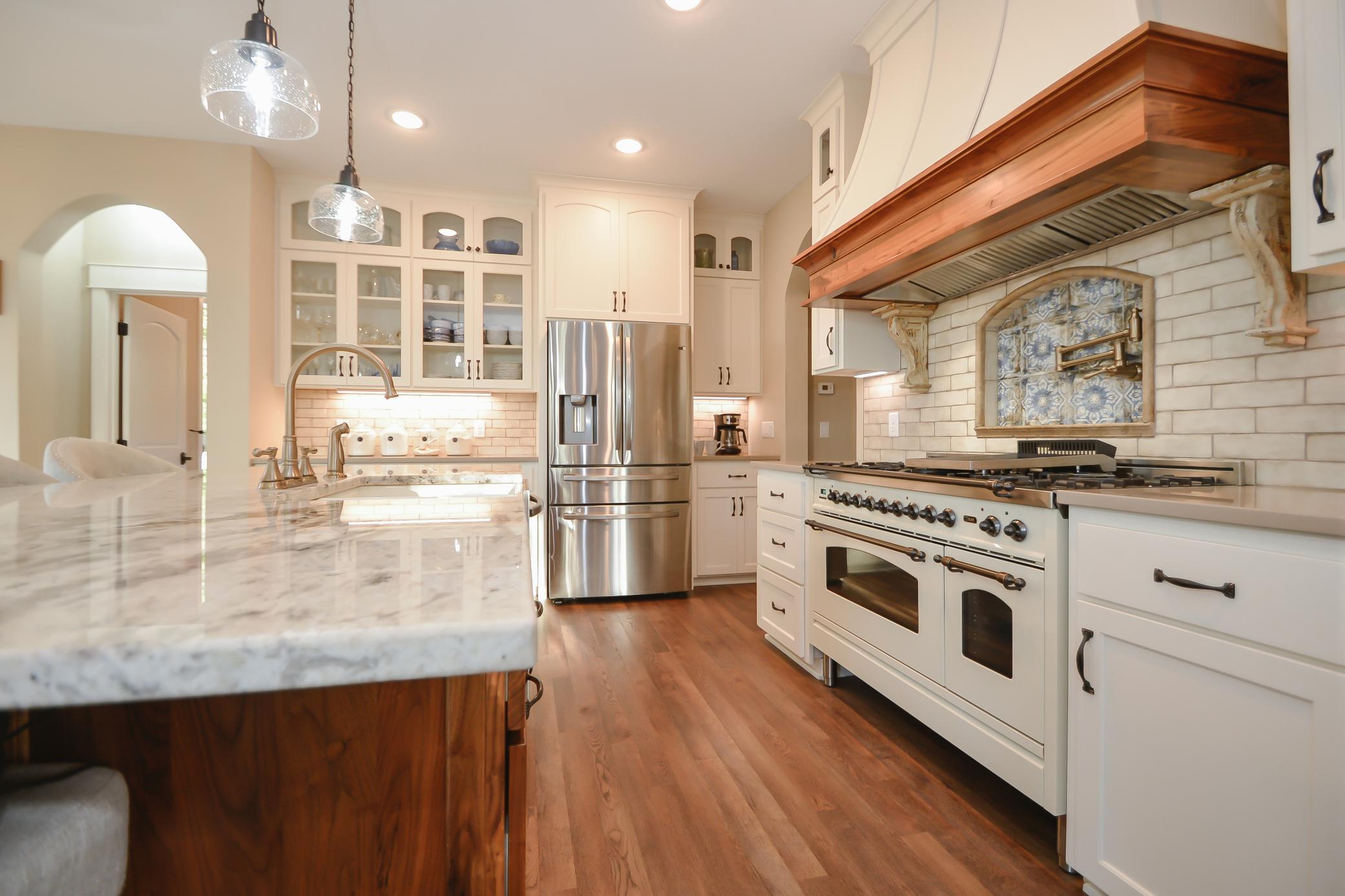 The gourmet kitchen showcases Schlangen's Custom black walnut island and painted cabinetry, quartz countertops, granite island, professional-grade appliances, and an Italian ILIVE oven.